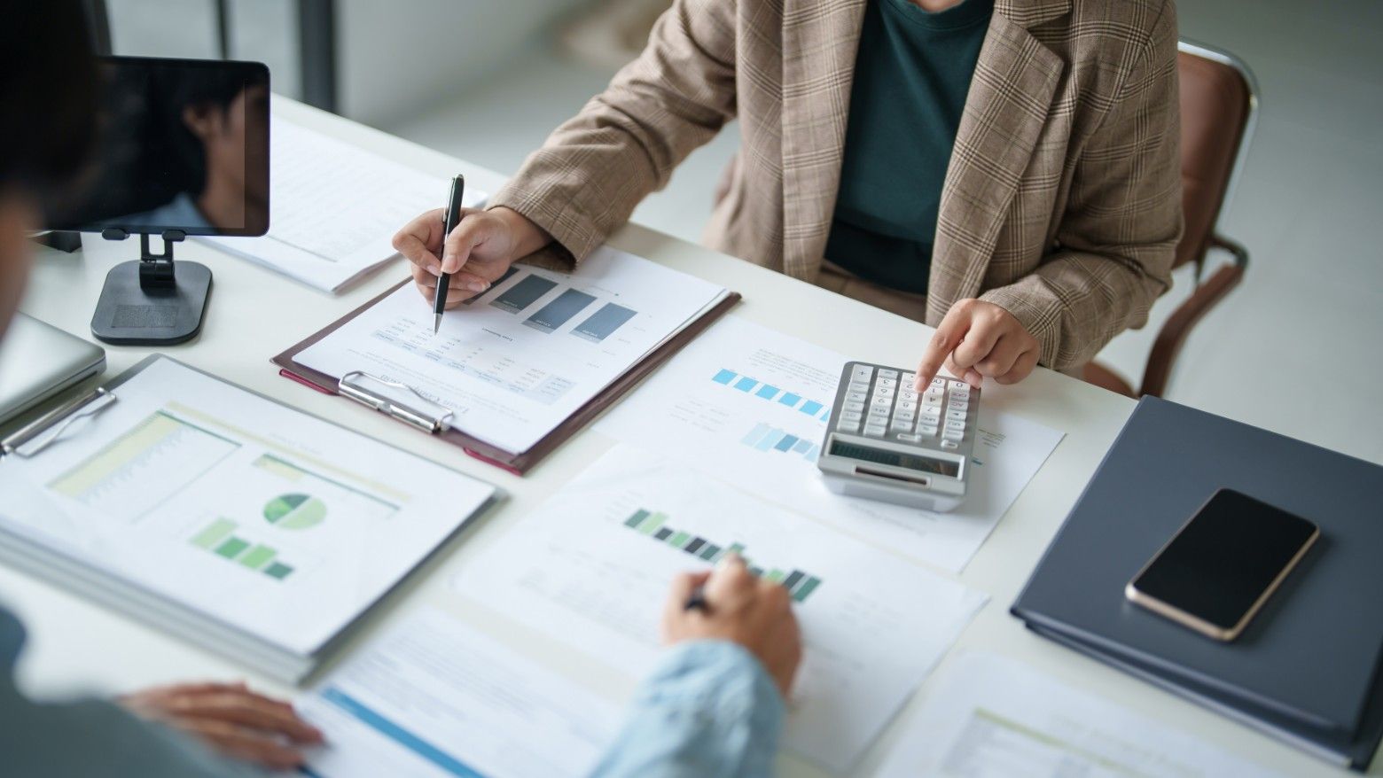 Two People Are Sitting at a Table With Papers and a Calculator — Eacham Accounting and Audits in Cape York, QLD