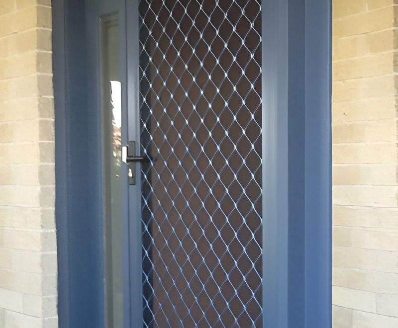 A Blue Door With a Mesh Screen on It — Elegant Blinds & Awnings in Forster, NSW