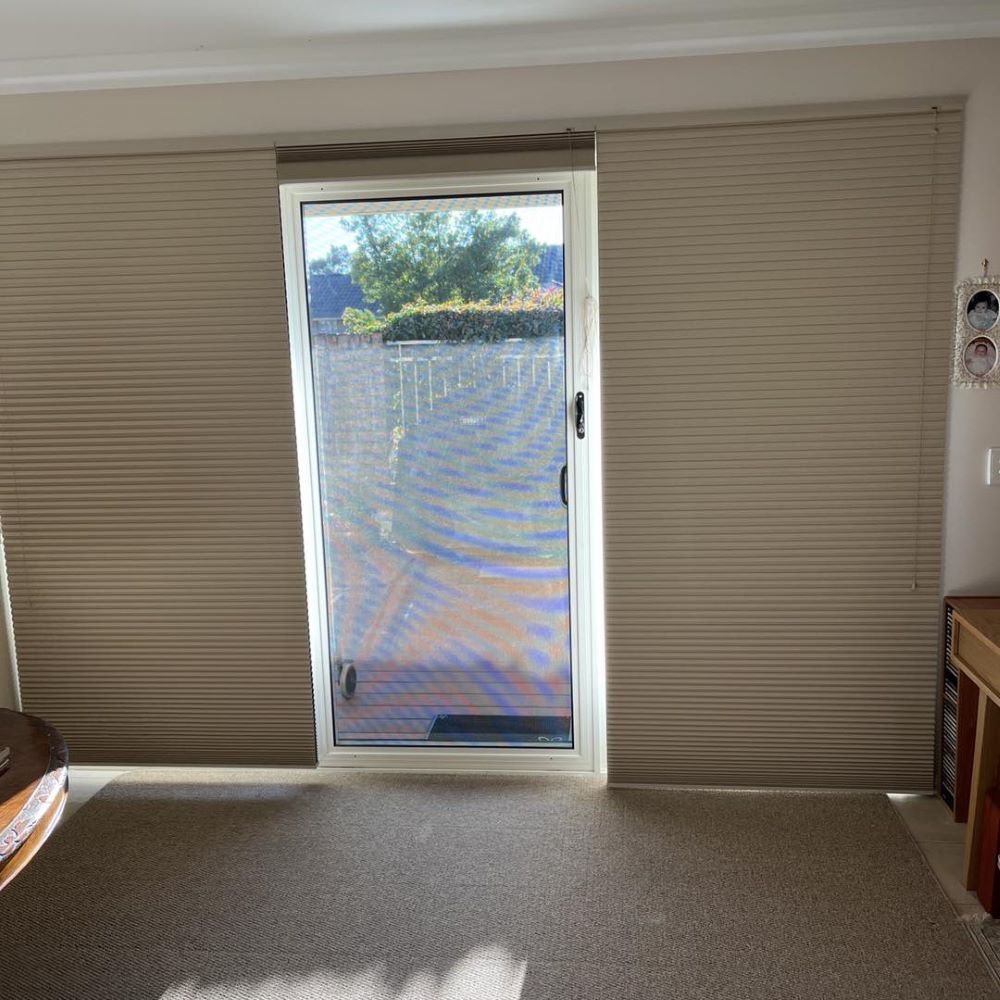 A Living Room With a Sliding Glass Door and Blinds — Elegant Blinds & Awnings in Forster, NSW