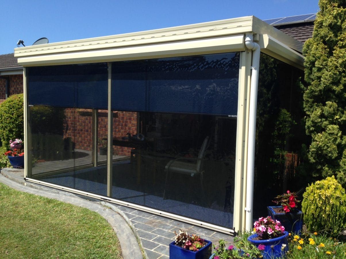 A Screened in Porch With a Table and Chairs in It — Elegant Blinds & Awnings in Forster, NSW