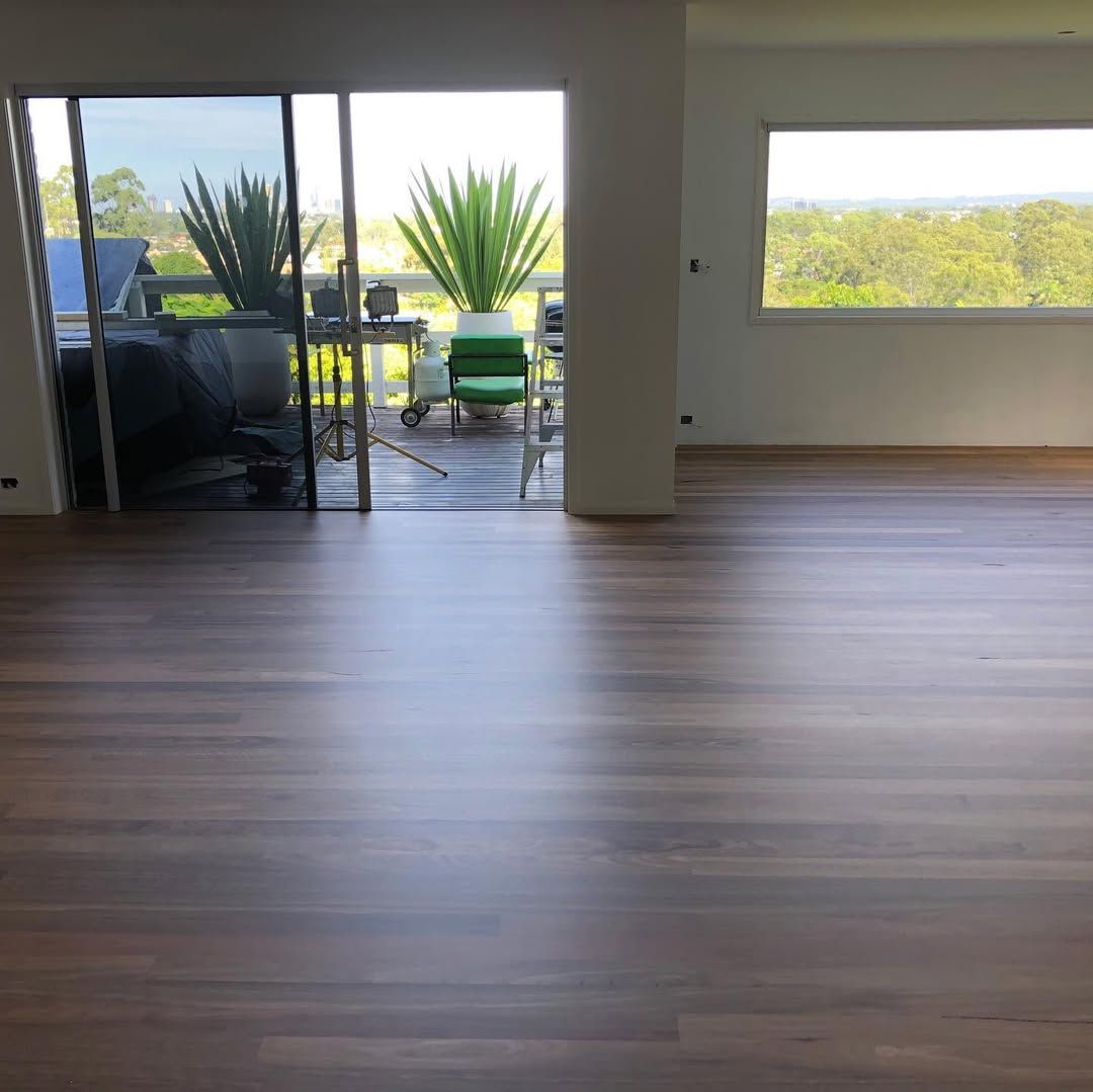 An Empty Room With Hardwood Floors and a Yellow Light — Tweed Coast Cork & Timber Floors In Tweed Heads, NSW