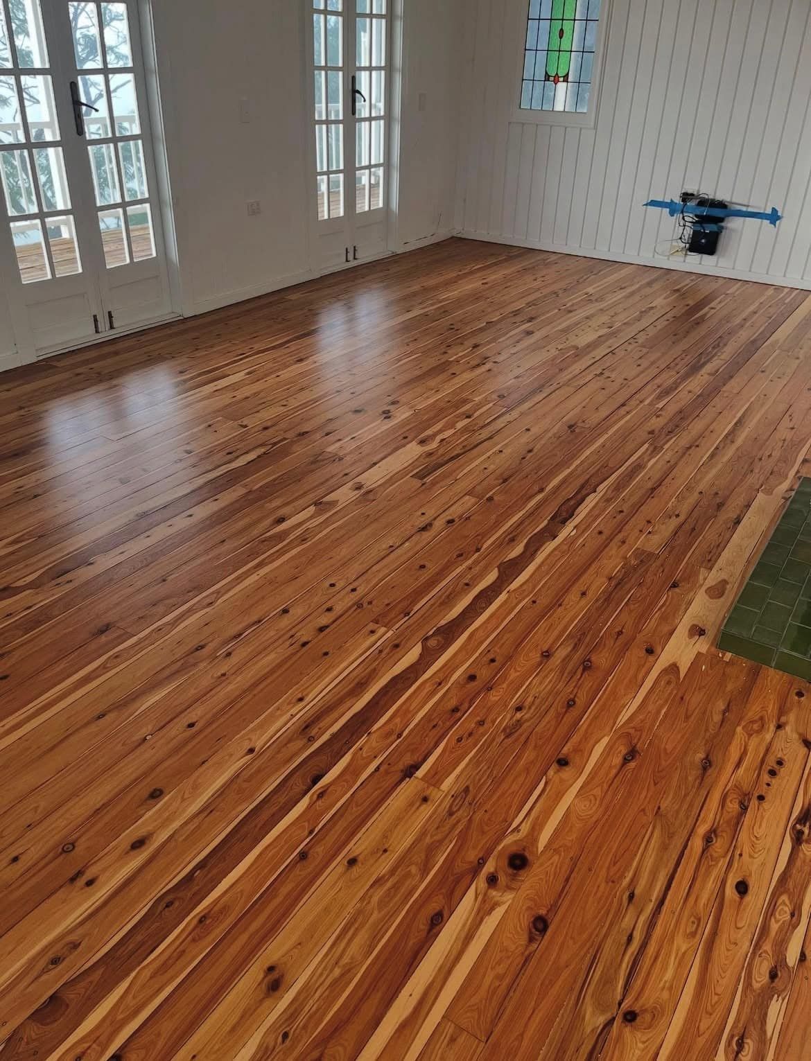 Wooden floor in a room with white walls, windows and a single stained glass panel. — Tweed Coast Cork & Timber Floors In Tweed Heads, NSW