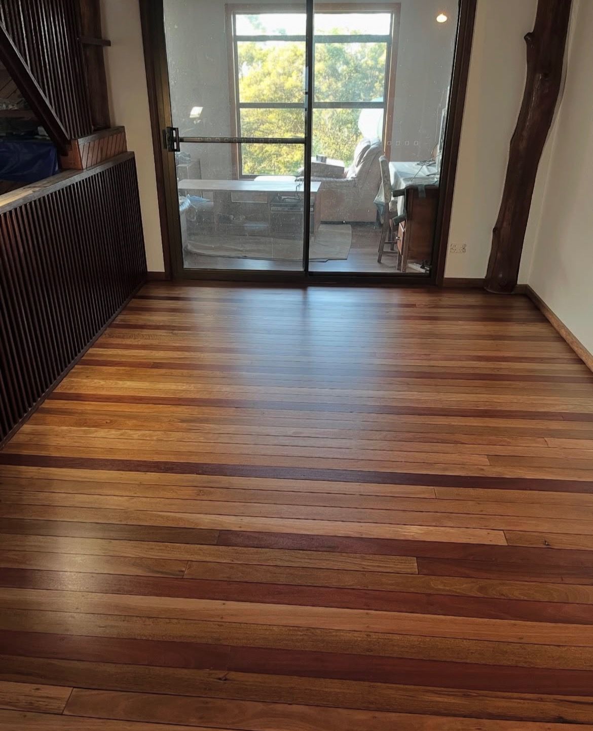 Wooden floor in an open room with a large window and wooden beams. — Tweed Coast Cork & Timber Floors In Tweed Heads, NSW