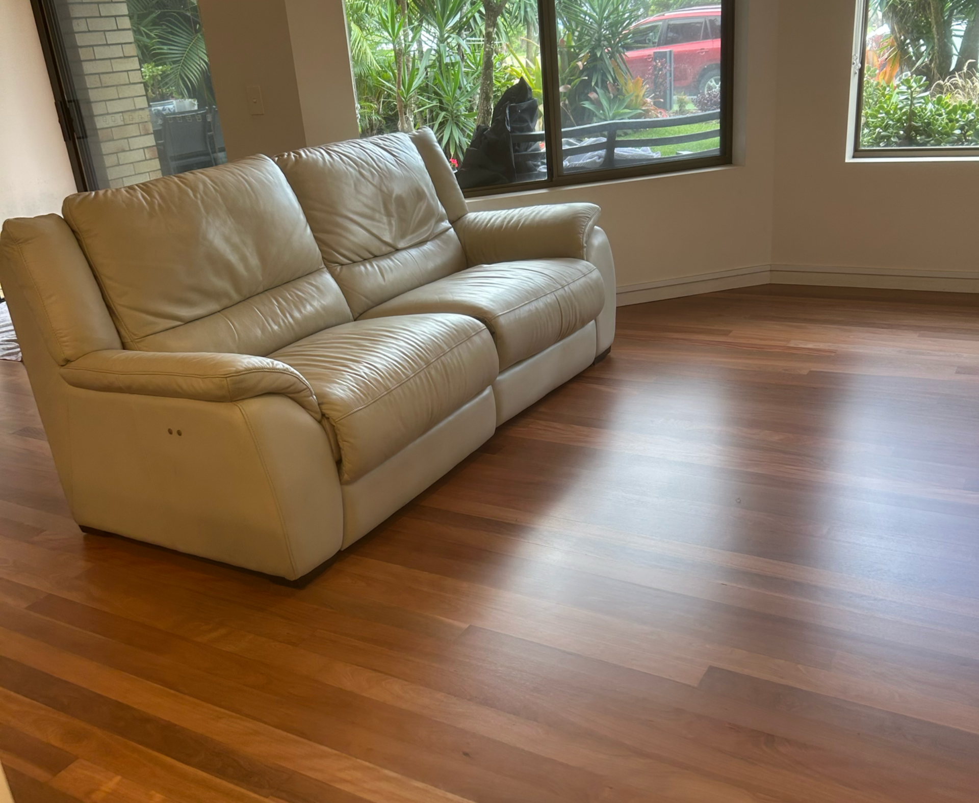 Beige leather sofa on hardwood floor next to a window in a room — Tweed Coast Cork & Timber Floors In Kingscliff, NSW