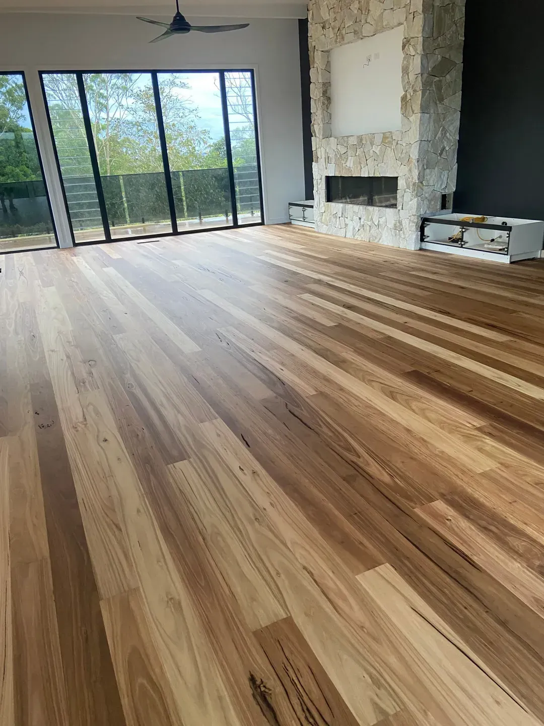 A Living Room With Smooth Hardwood Floors and a Fireplace — Tweed Coast Cork & Timber Floors In Tweed Heads, NSW