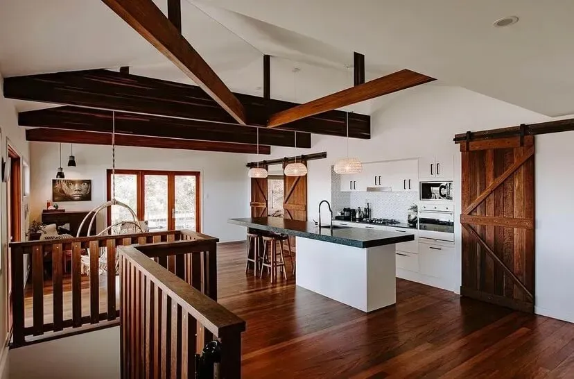 A Kitchen With a Sliding Barn Door and Wooden Beams — Tweed Coast Cork & Timber Floors In Tweed Heads, NSW