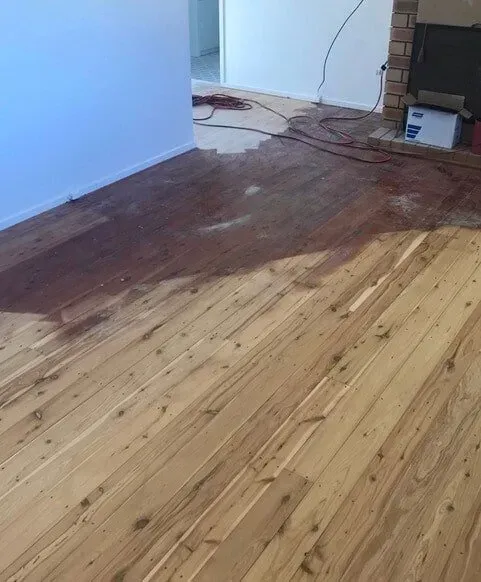 A Wooden Floor is Being Painted in a Living Room — Tweed Coast Cork & Timber Floors In Tweed Heads, NSW