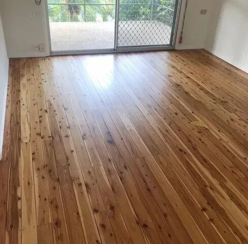 A Living Room With a Wooden Floor and a Sliding Glass Web Door — Tweed Coast Cork & Timber Floors In Tweed Heads, NSW