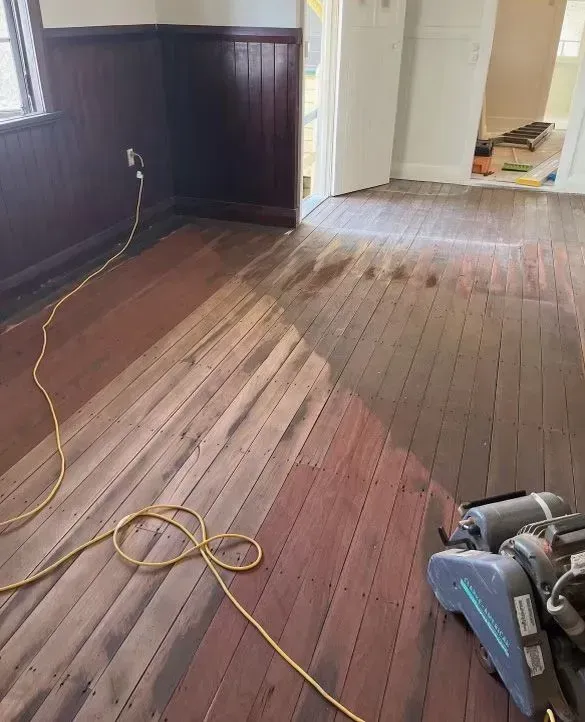 A Vacuum Cleaner is Sitting on a Wooden Floor in a Room — Tweed Coast Cork & Timber Floors In Tweed Heads, NSW