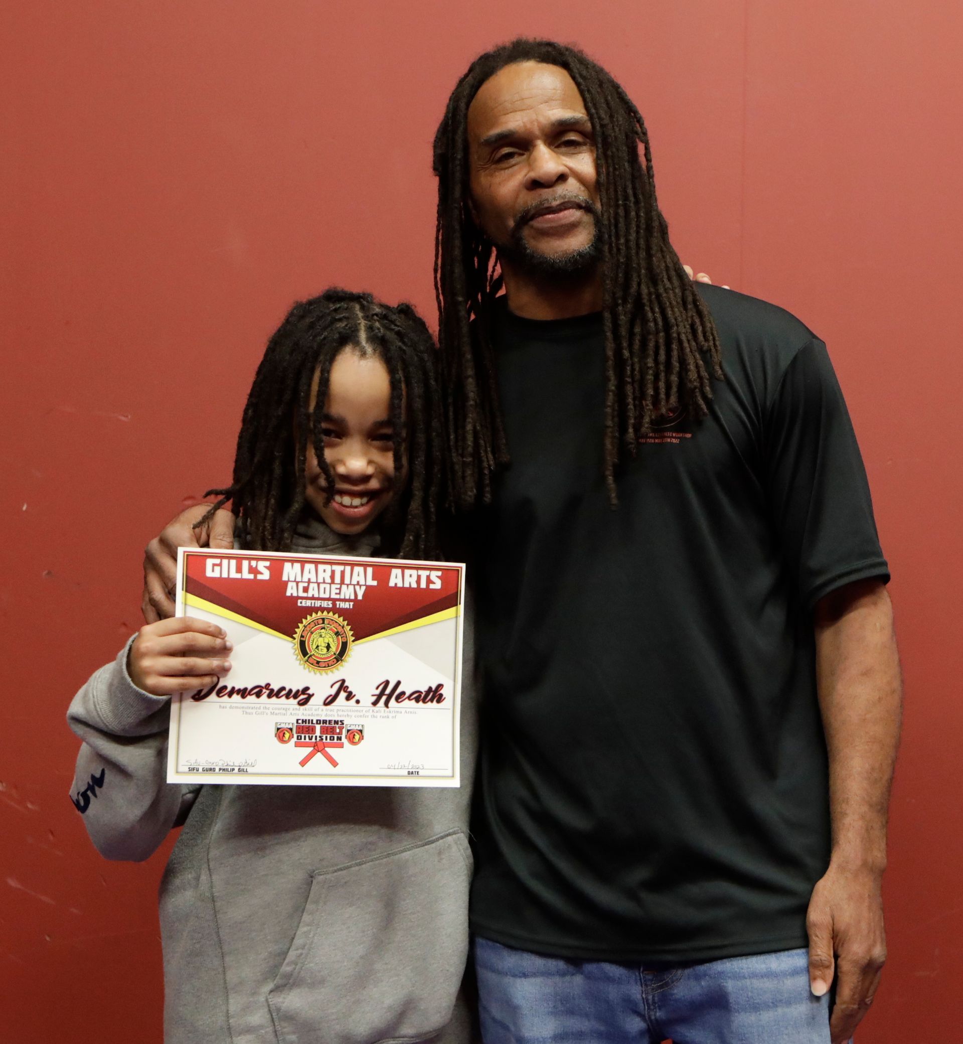 A man and a girl are posing for a picture and the girl is holding a certificate