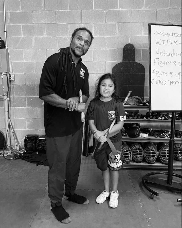 A man and a little girl are standing next to each other in a black and white photo.