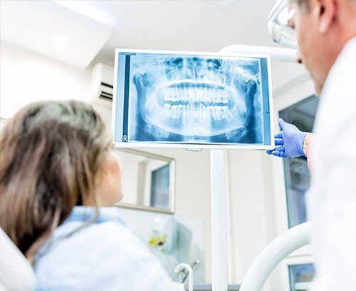 dentist showing patient picture of her teeth