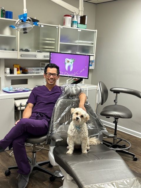 Dr. Ta is sitting in a dental chair with Watson next to him.