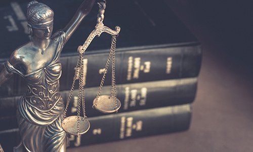 Bilancia della giustizia accanto a libri di giurisprudenza