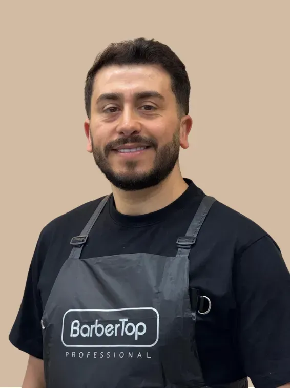 Man met zwart schort aan, lachend, met 