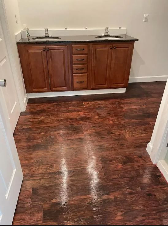 A man is using a high pressure washer to clean a brick wall.