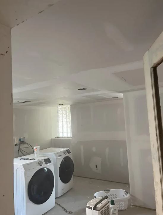 A long hallway with a couch and a potted plant.