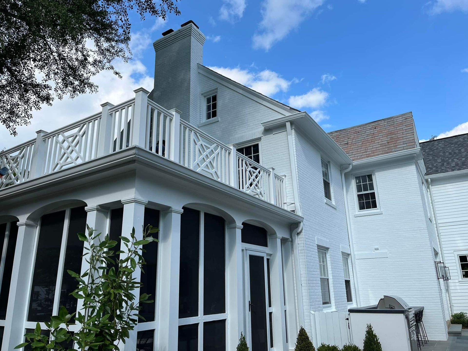 A large white house with a screened in porch
