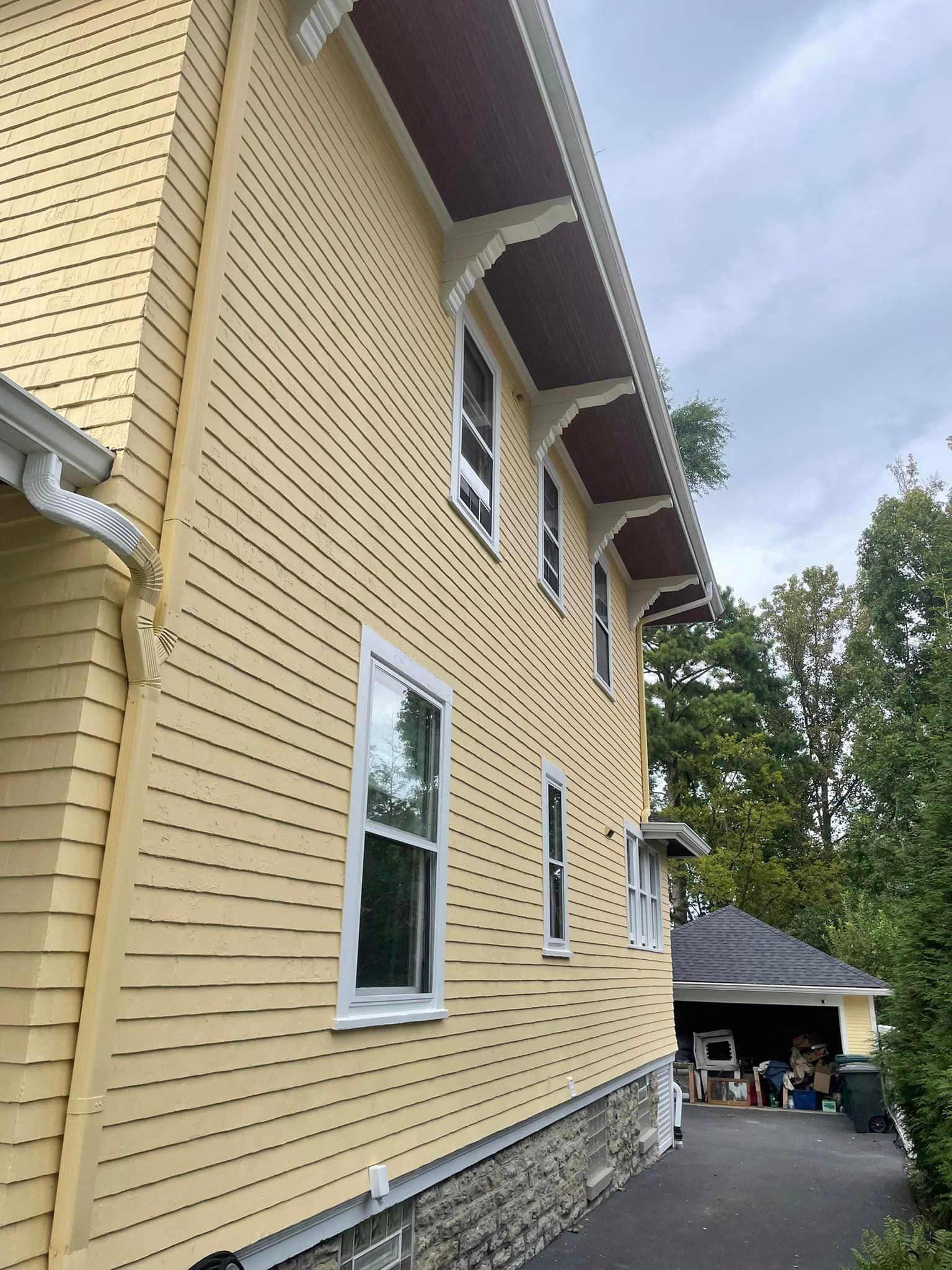 A large yellow house with a lot of windows and a garage.