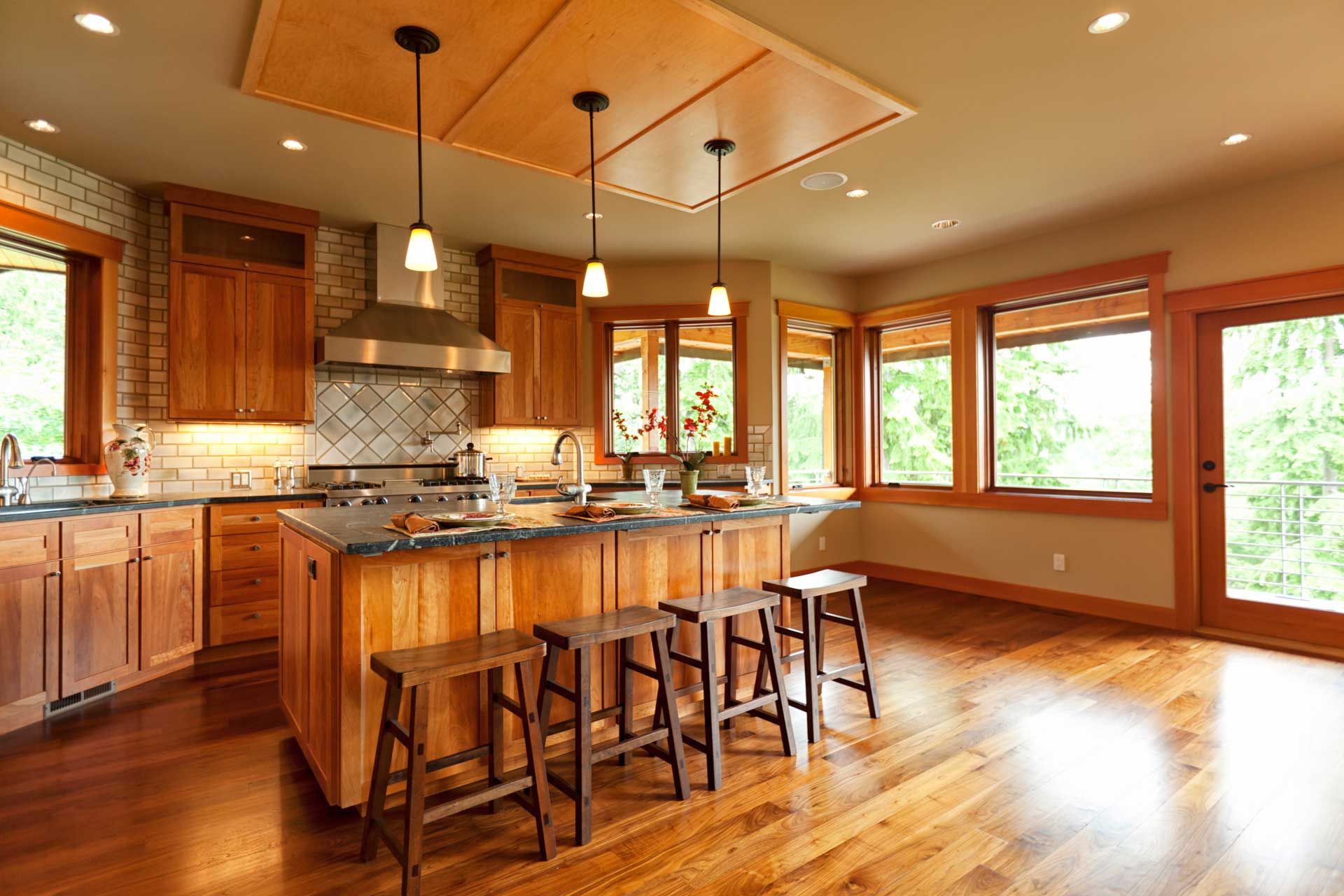 A kitchen with wooden cabinets and stools and a large island