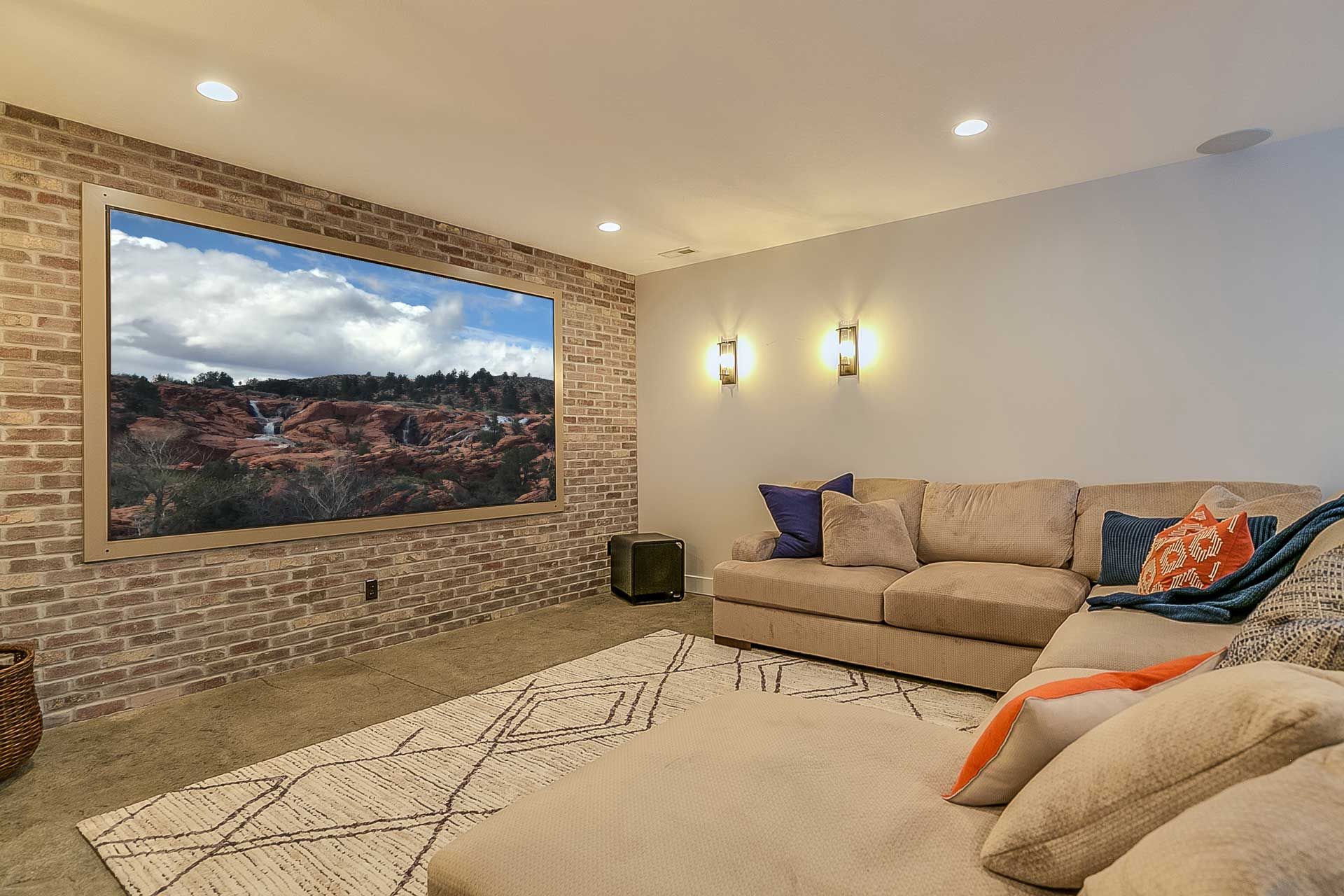 A living room with a couch and a large screen tv.