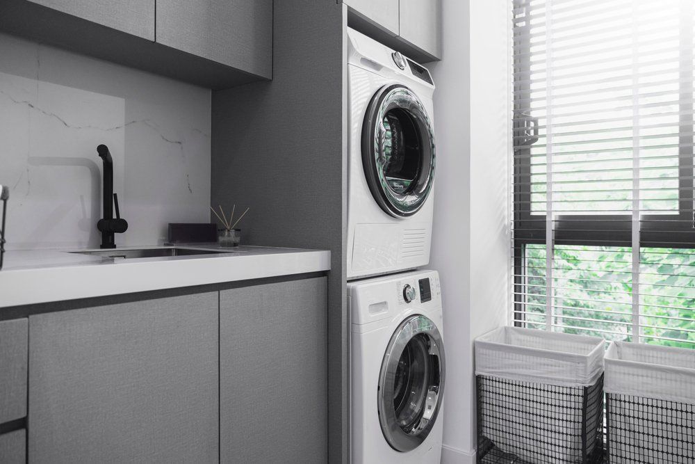 A Laundry Room with A Washer and Dryer Stacked on Top of Each Other — Bestbuy Kitchens in Yandina, QLD