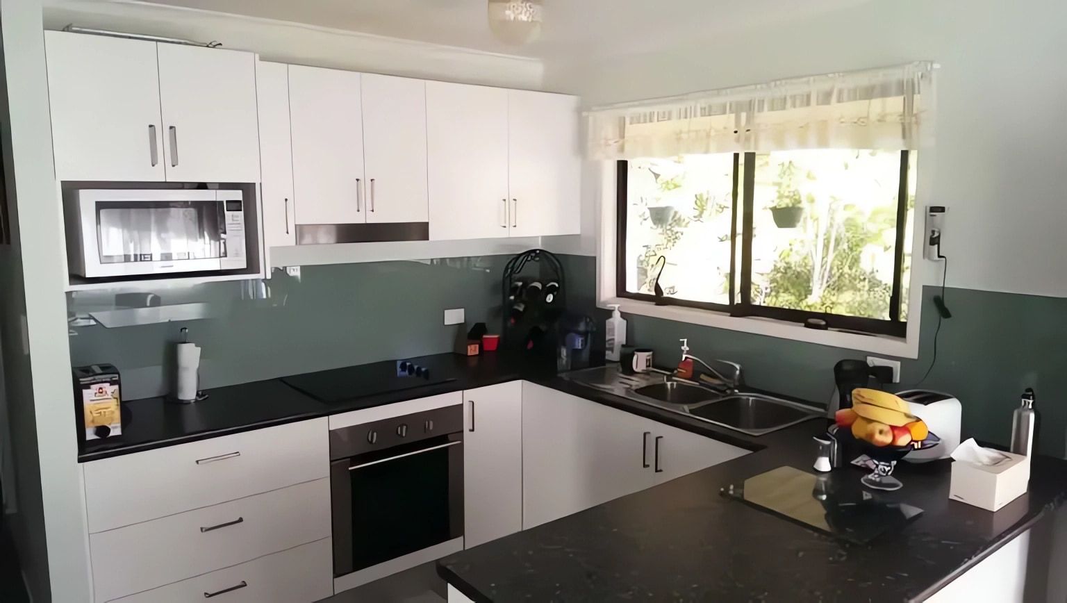 A Kitchen with White Cabinets and Black Counter Tops — Bestbuy Kitchens in Yandina, QLD