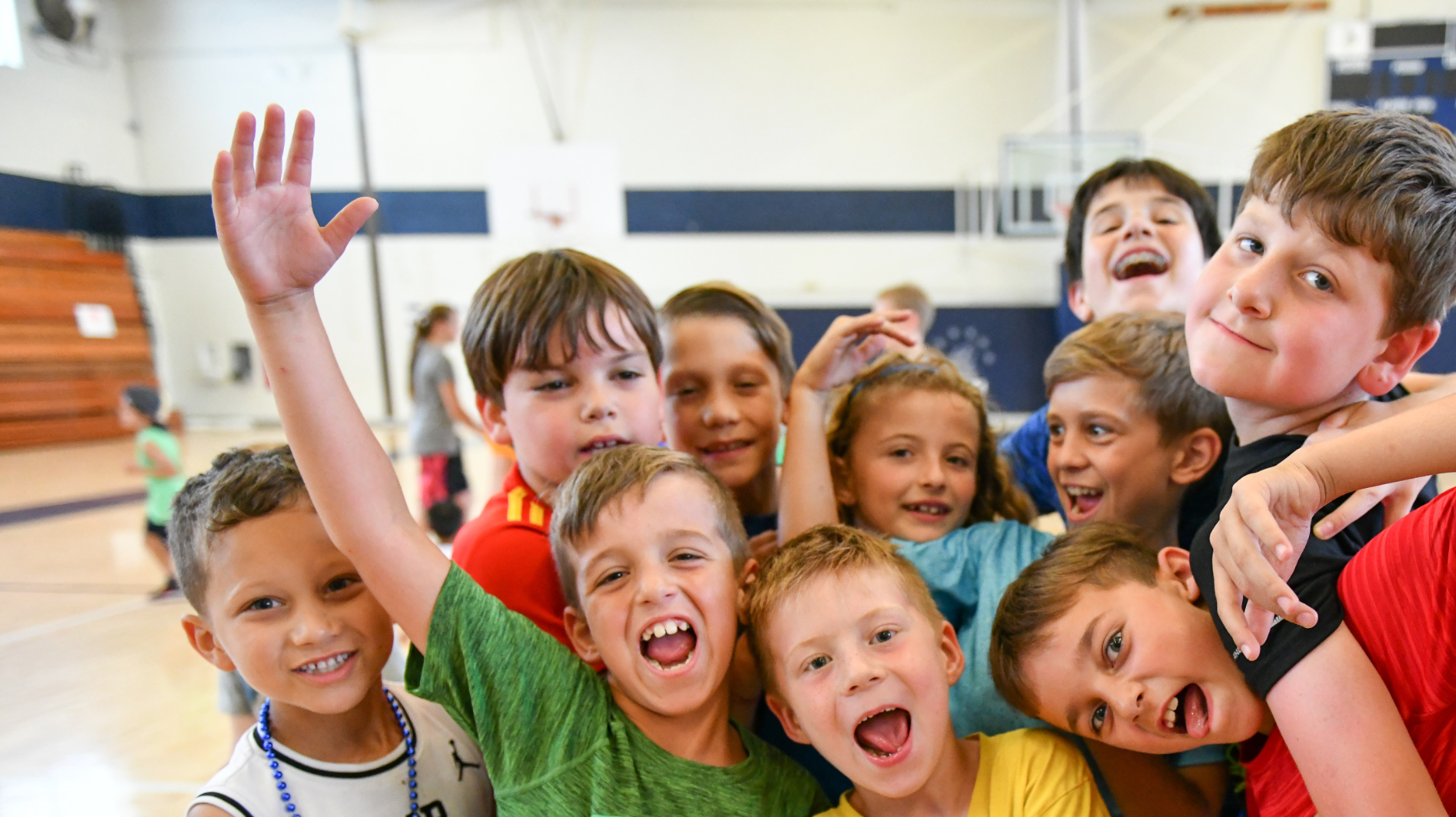 A group of young children are posing for a picture in a gym.