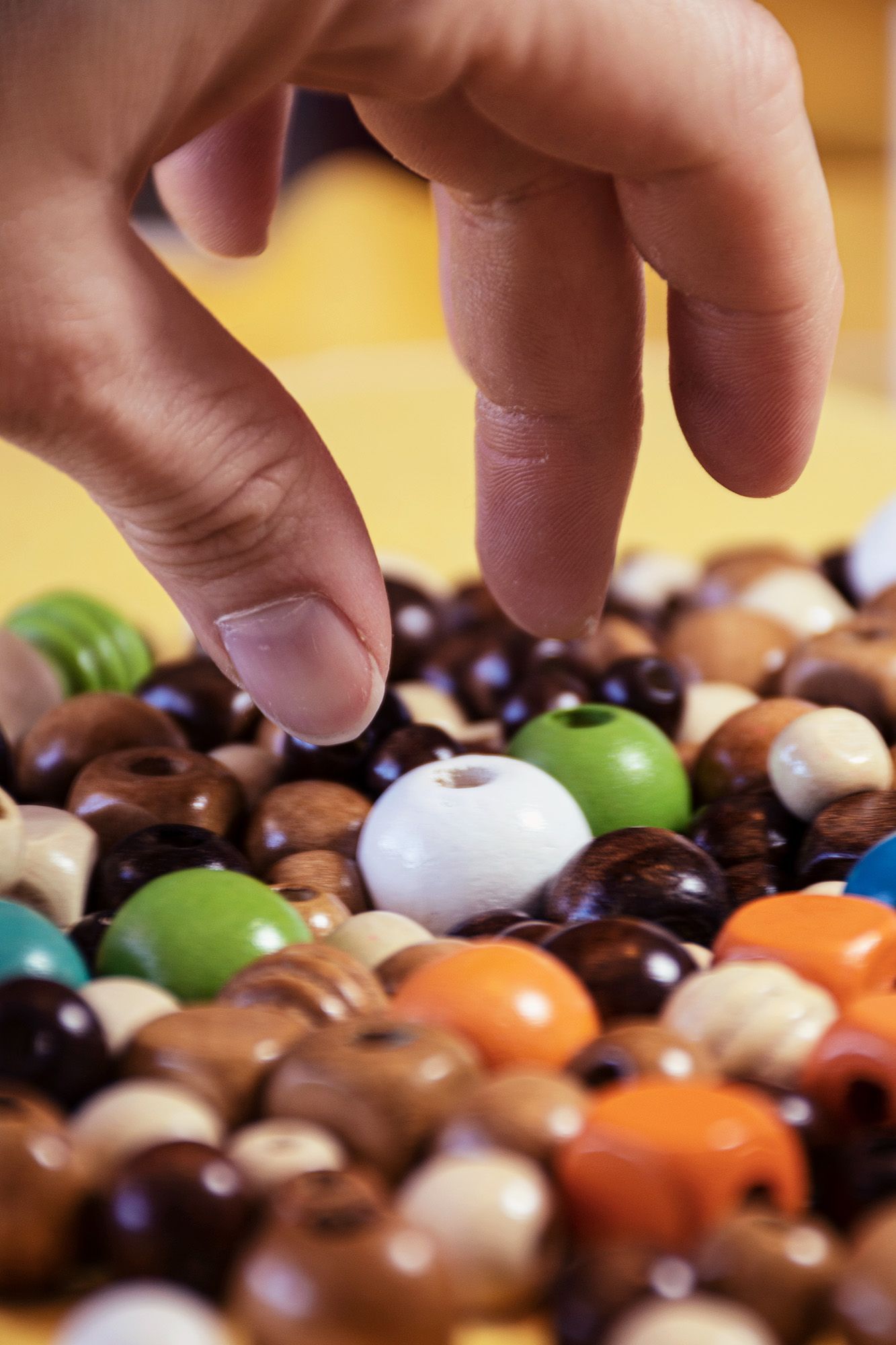 Hands reaching for pile of jewellery beads | NDIS Beading Classes by Spotty Dog Studios on the Gold Coast