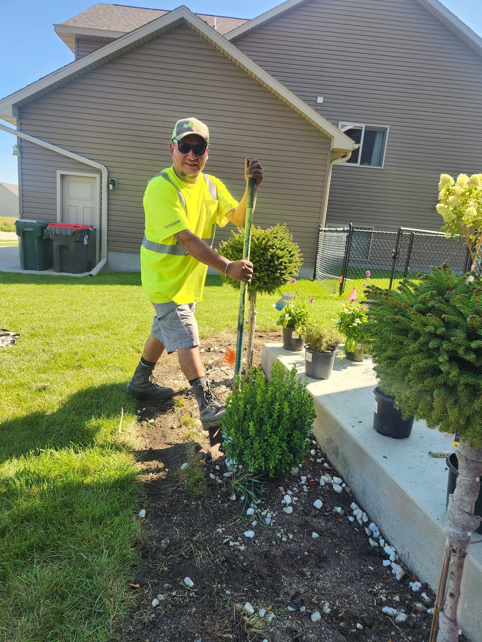 A man is standing in a garden in front of a house.