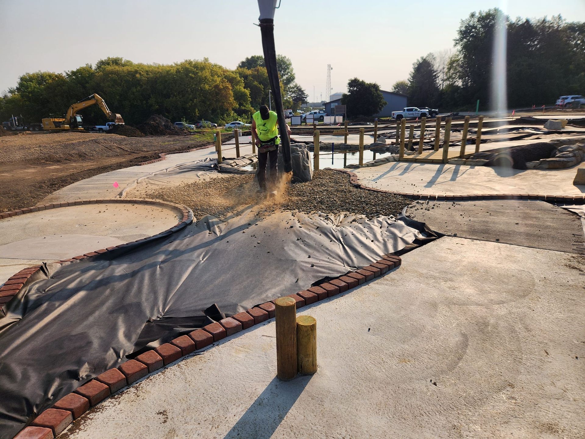 A man is pumping concrete into a hole in the ground