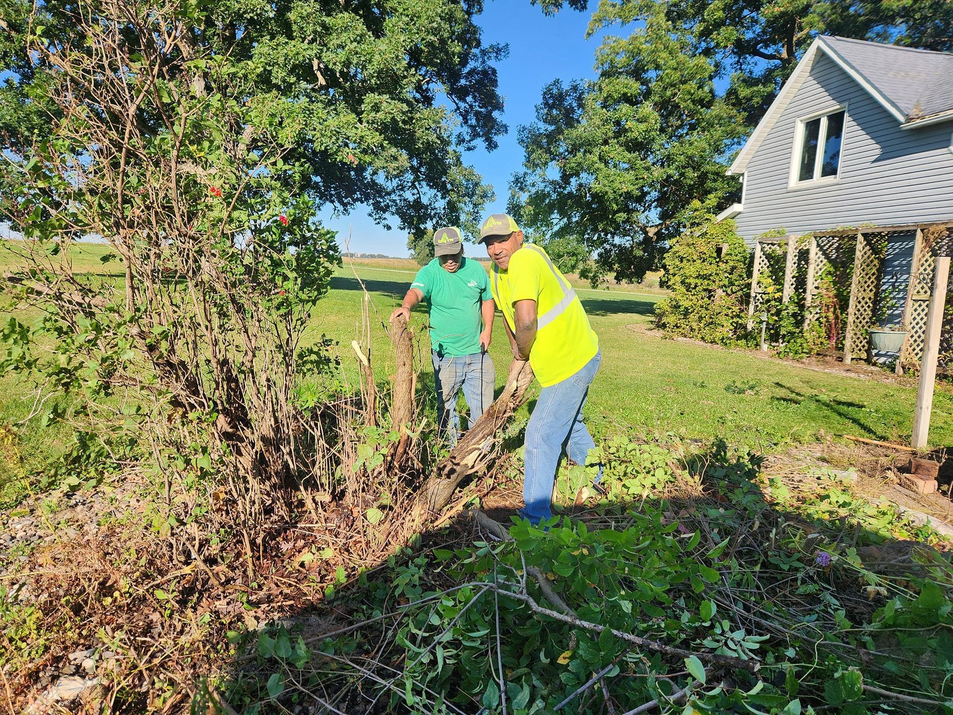 Two men are standing in a field next to a house.