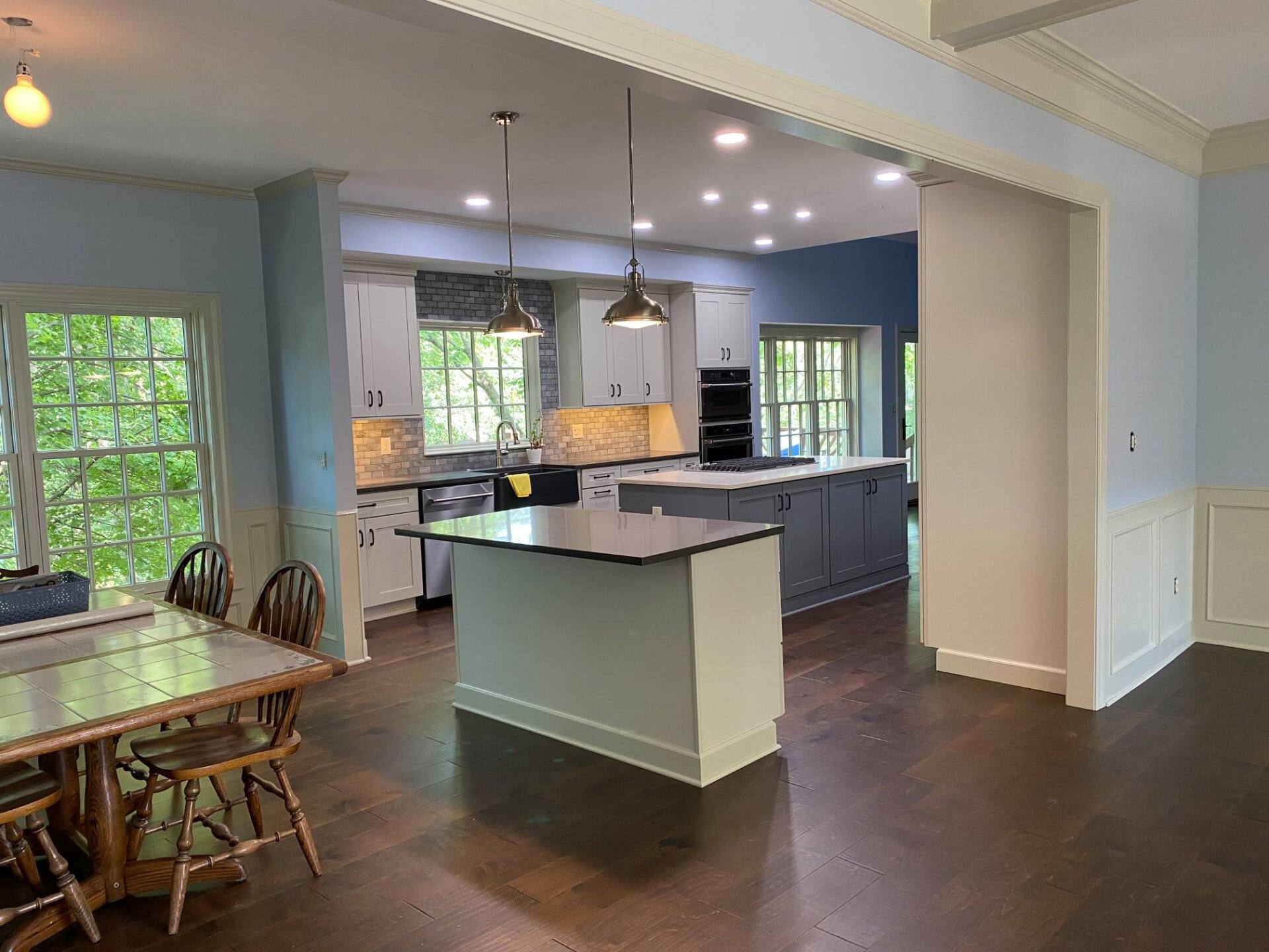 a kitchen with black cabinets and a stainless steel refrigerator