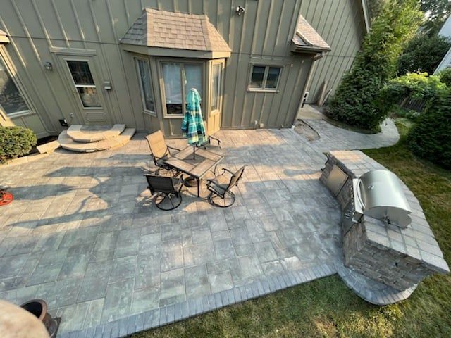 an aerial view of a patio with a table and chairs and a grill .