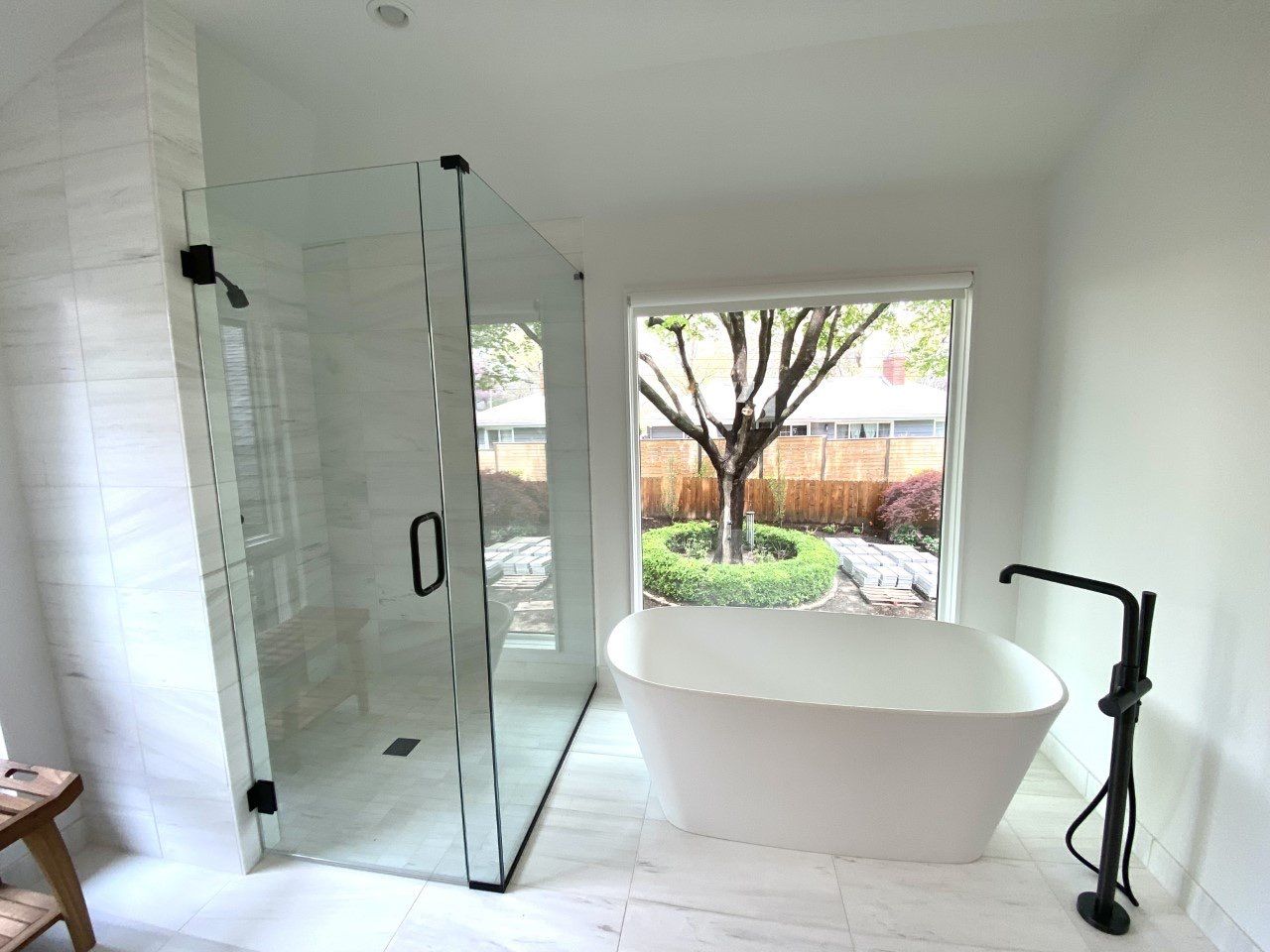 a bathroom remodel with a bathtub and a large window