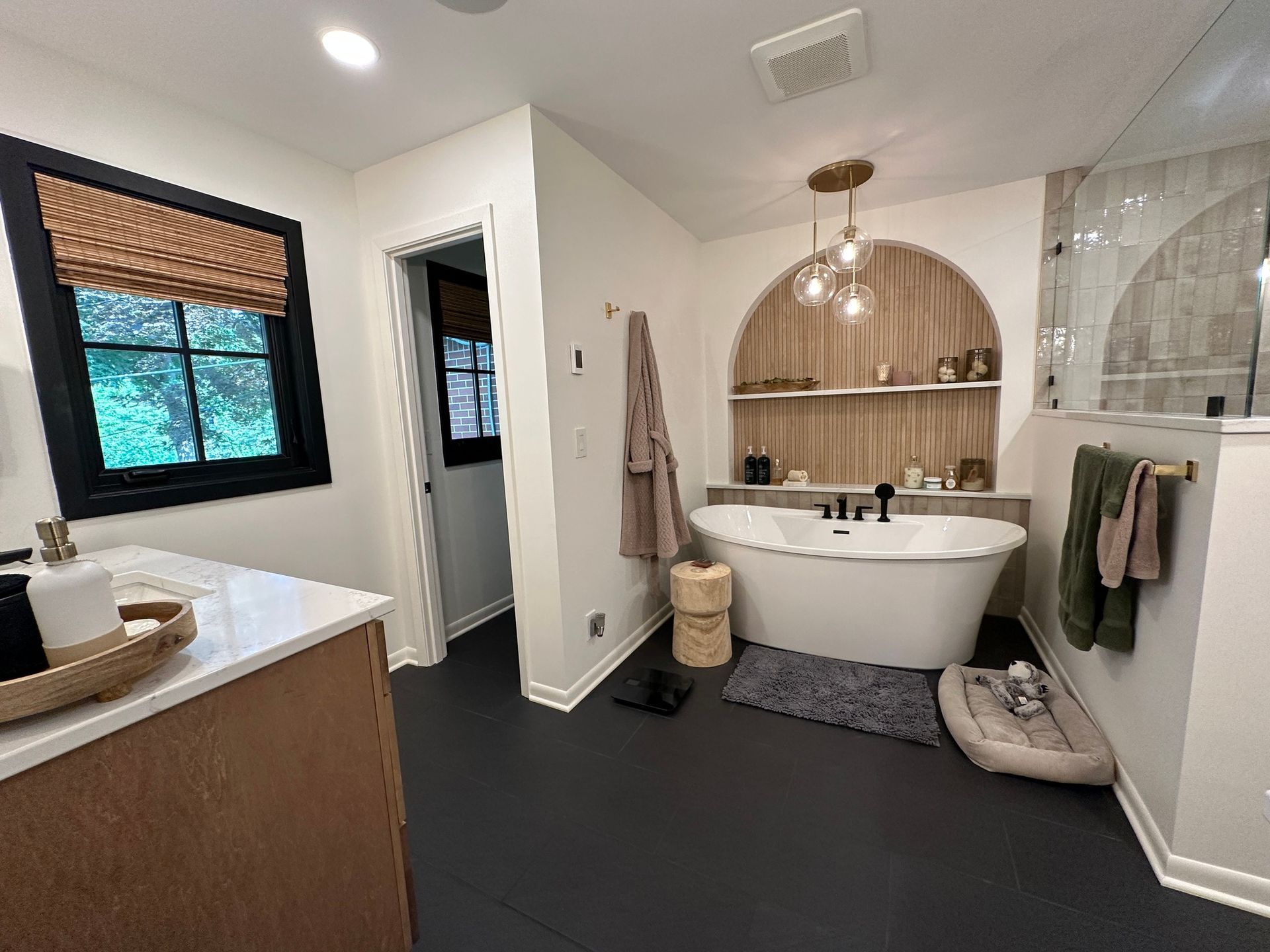 a bathroom remodel with a bathtub and a dog bed