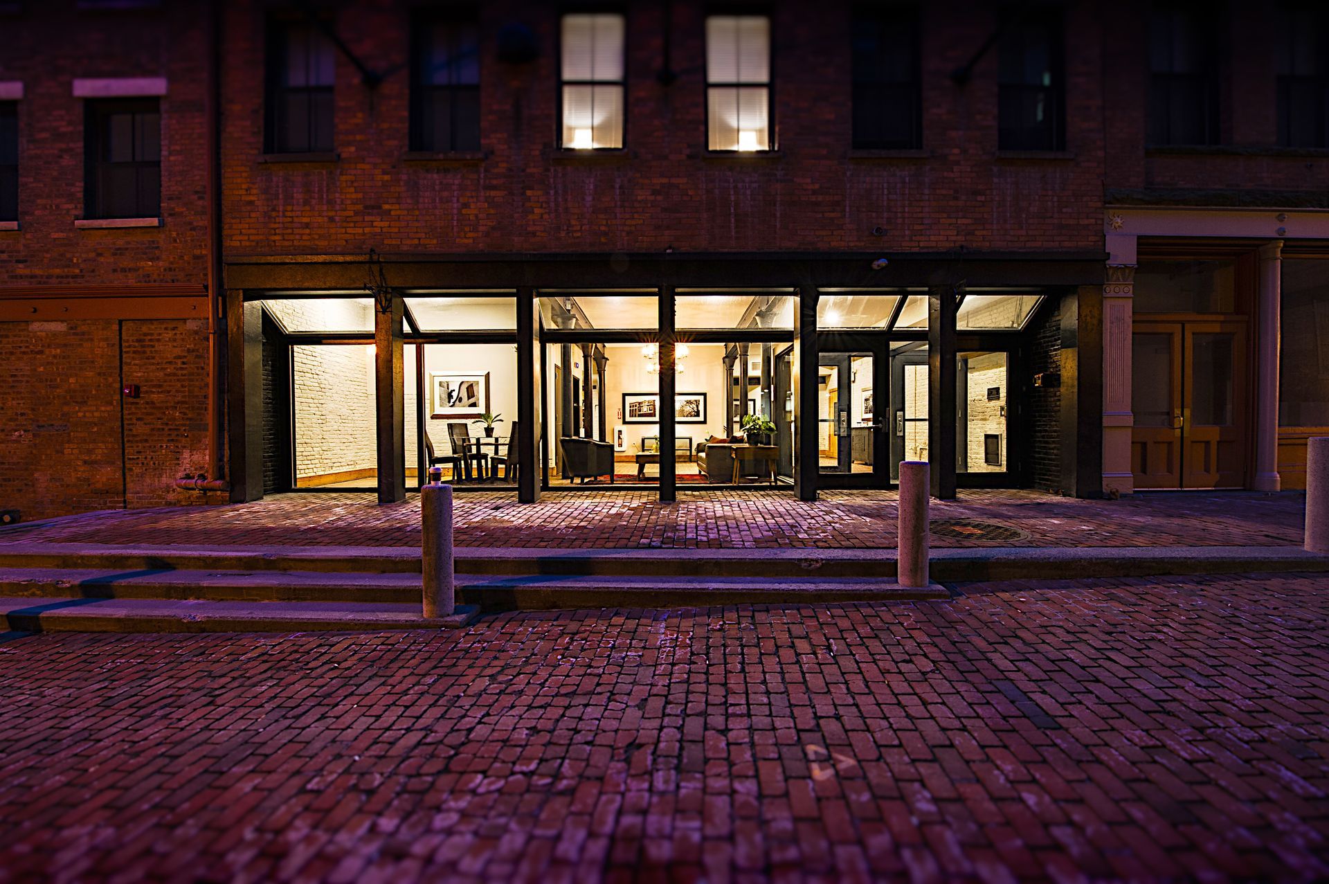 A brick building with a lot of windows is lit up at night