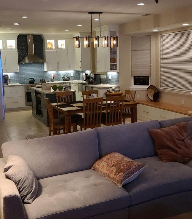 A living room with a couch and a kitchen in the background