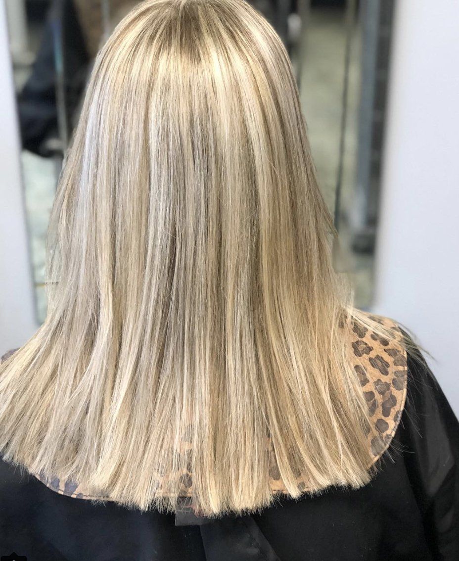 The back of a woman 's blonde hair is shown in a leopard print cape.