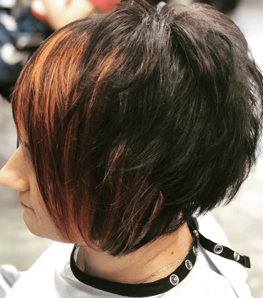 A woman with short hair has a choker around her neck