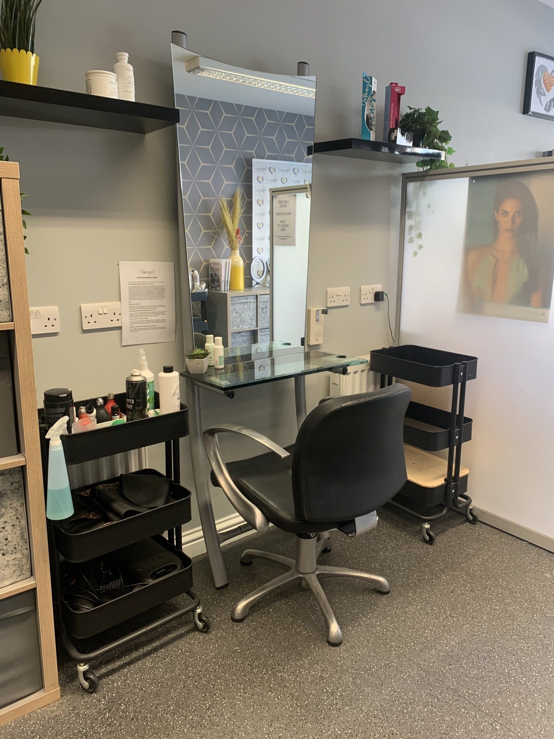 A hair salon with a chair and a mirror.