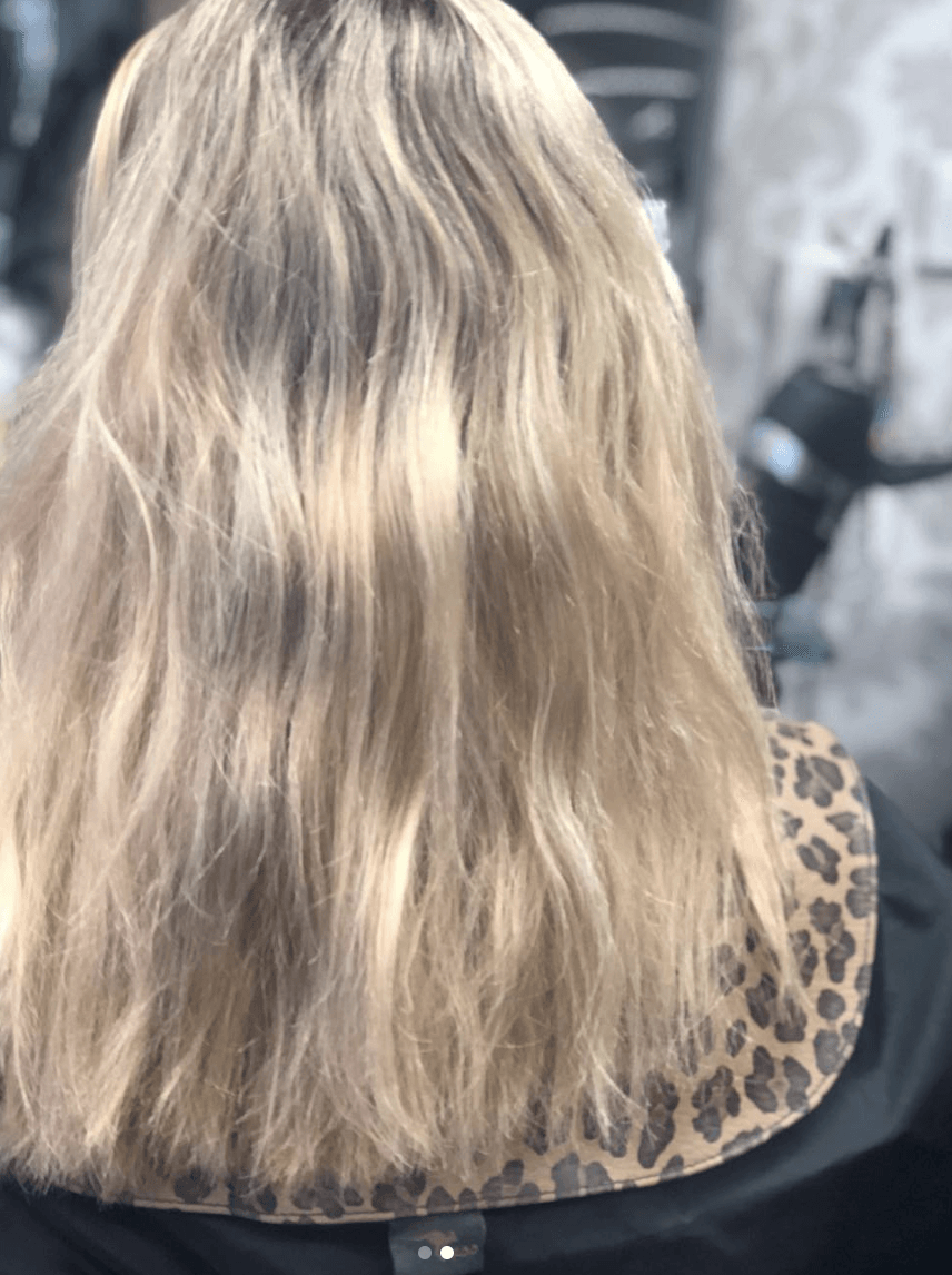 A woman with long blonde hair is wearing a leopard print cape.