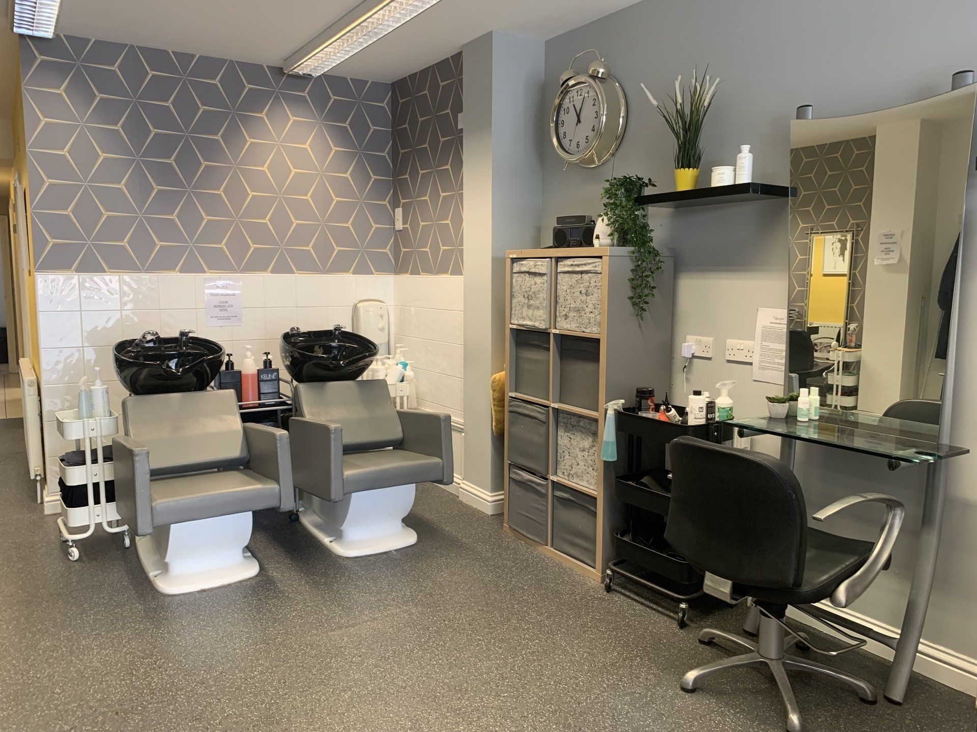 A hair salon with two chairs and a sink.