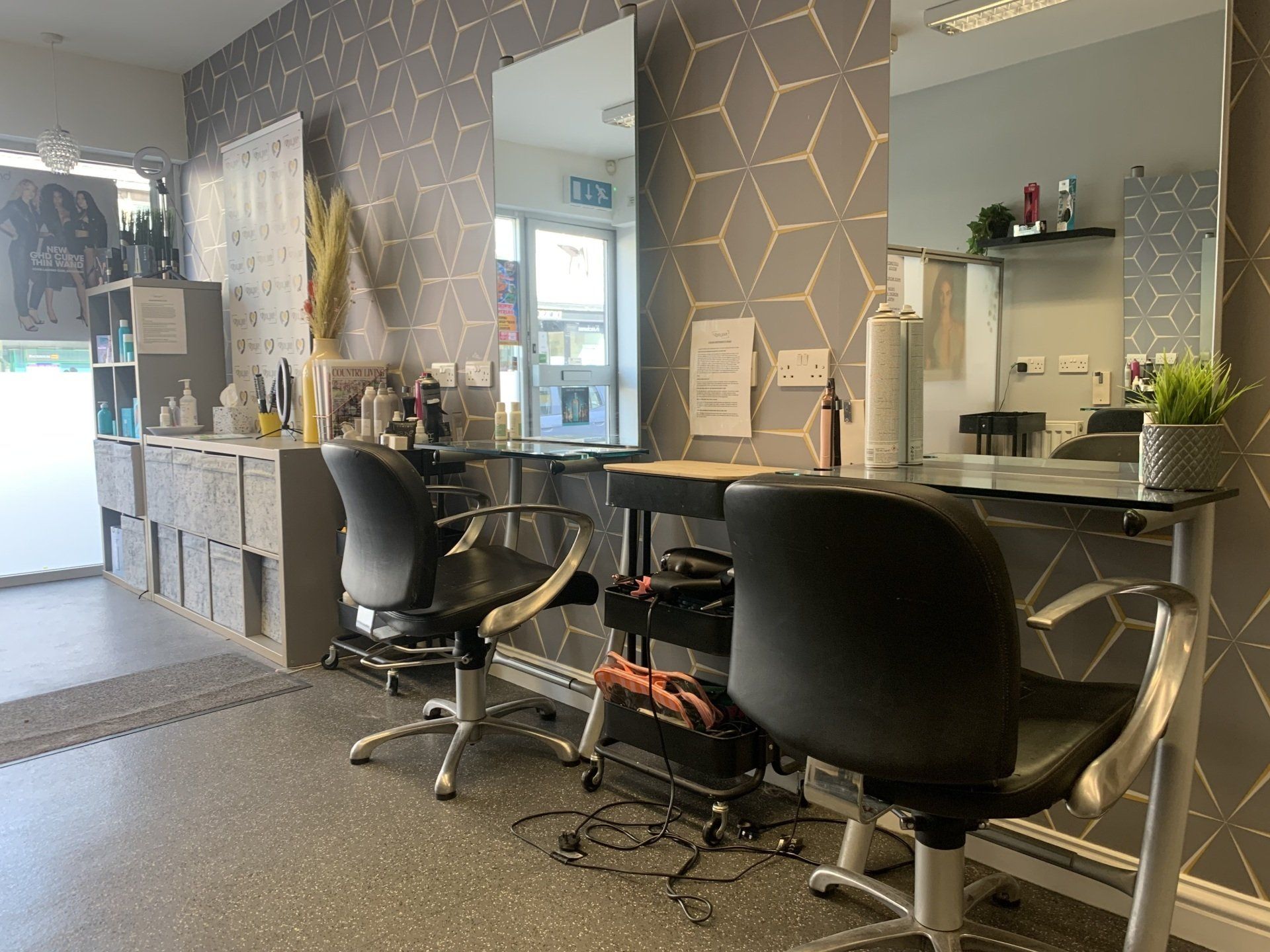 A hair salon with two chairs and two mirrors.