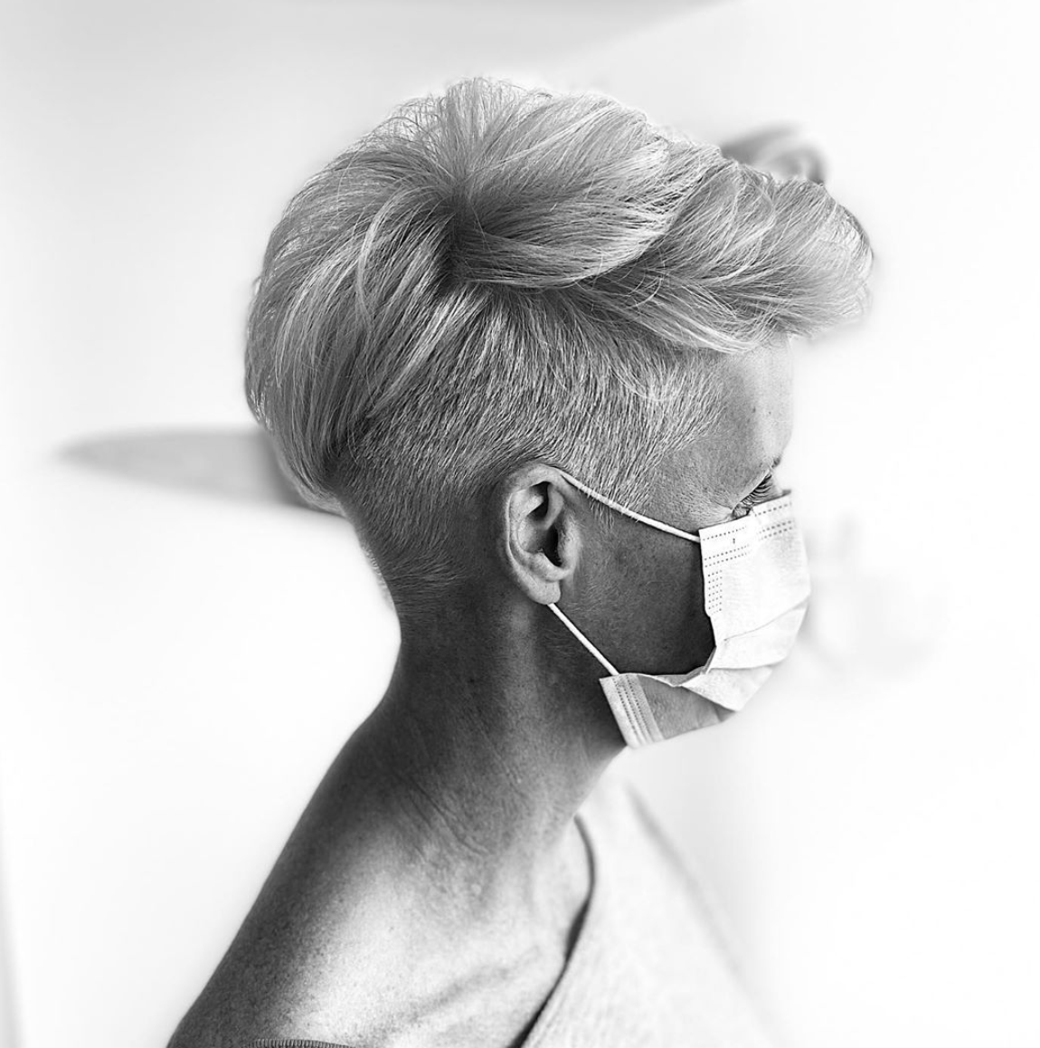 A black and white photo of a woman wearing a face mask.