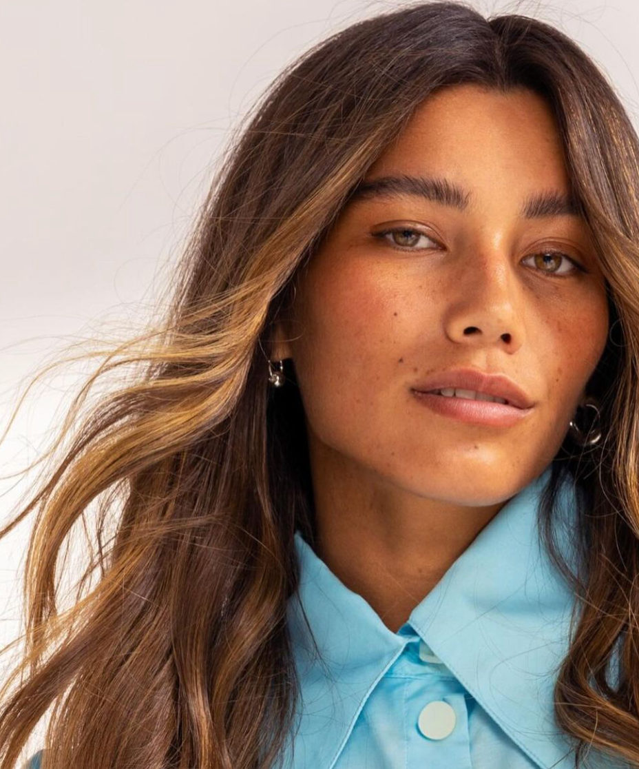 A close up of a woman wearing a blue shirt