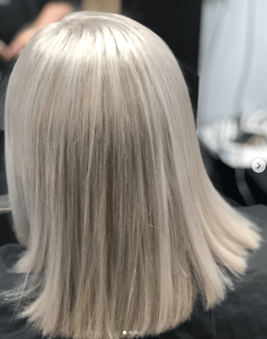 A woman with blonde hair is sitting in a chair.