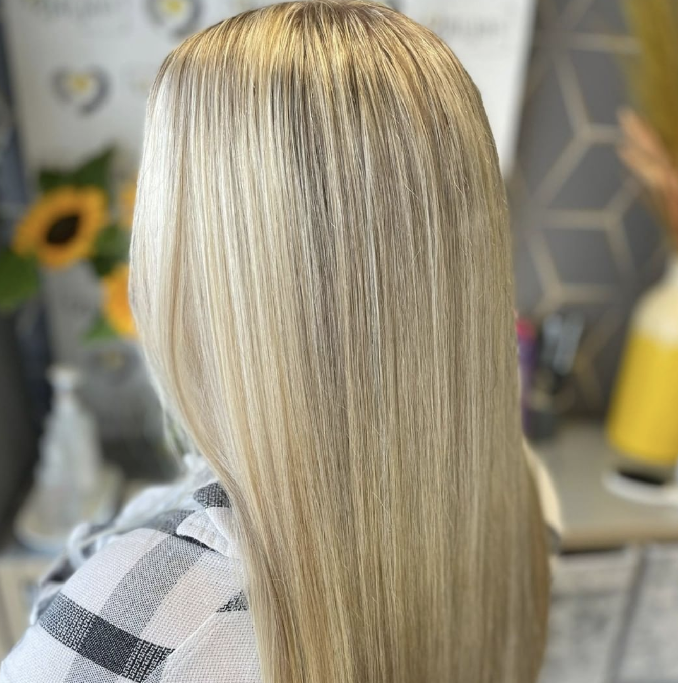 A woman with long blonde hair is sitting in a chair.