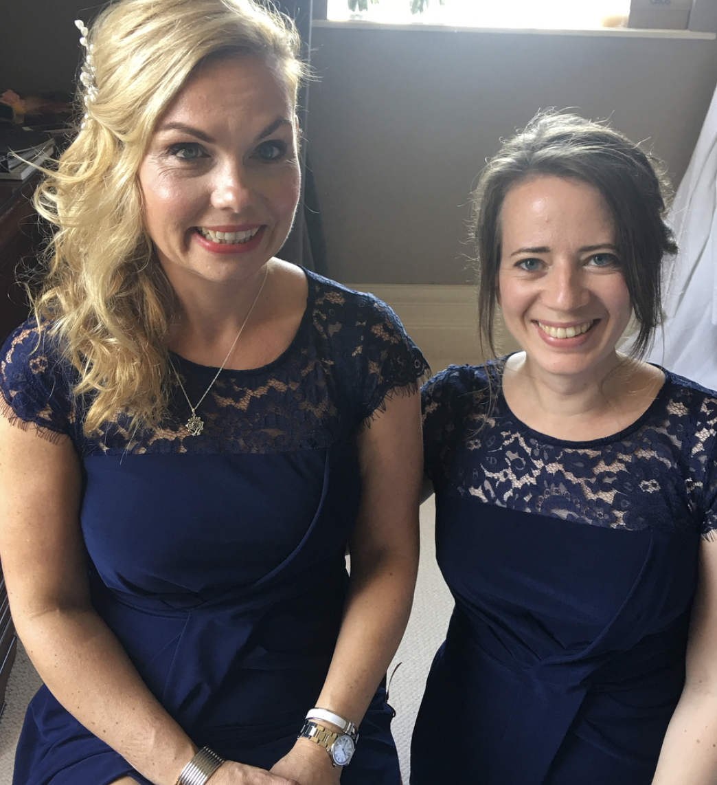 Two women in blue dresses are posing for a picture