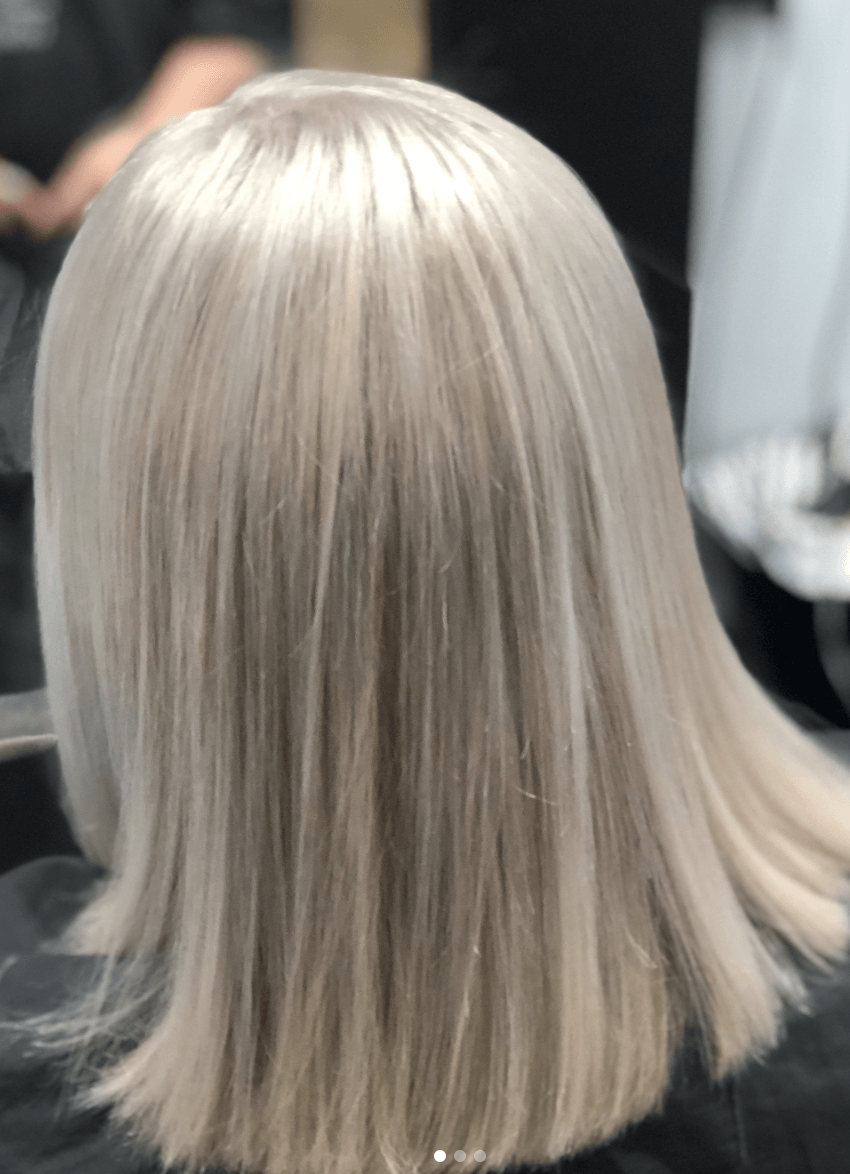 A woman with blonde hair is sitting in a chair